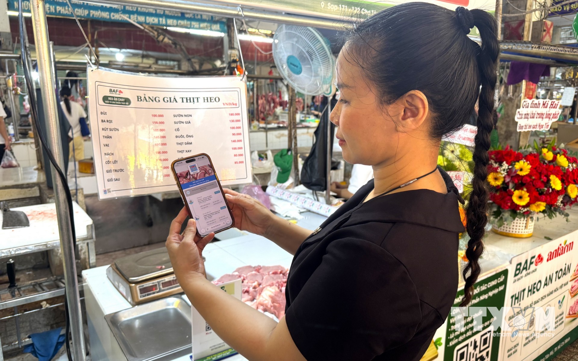 Người dân TP. Hồ Chí Minh quét mã để truy xuất thông tin về sản phẩm thịt lợn, từ trang trại đến quá trình vận chuyển, giết mổ. (Ảnh: Hương Giang/TTXVN)